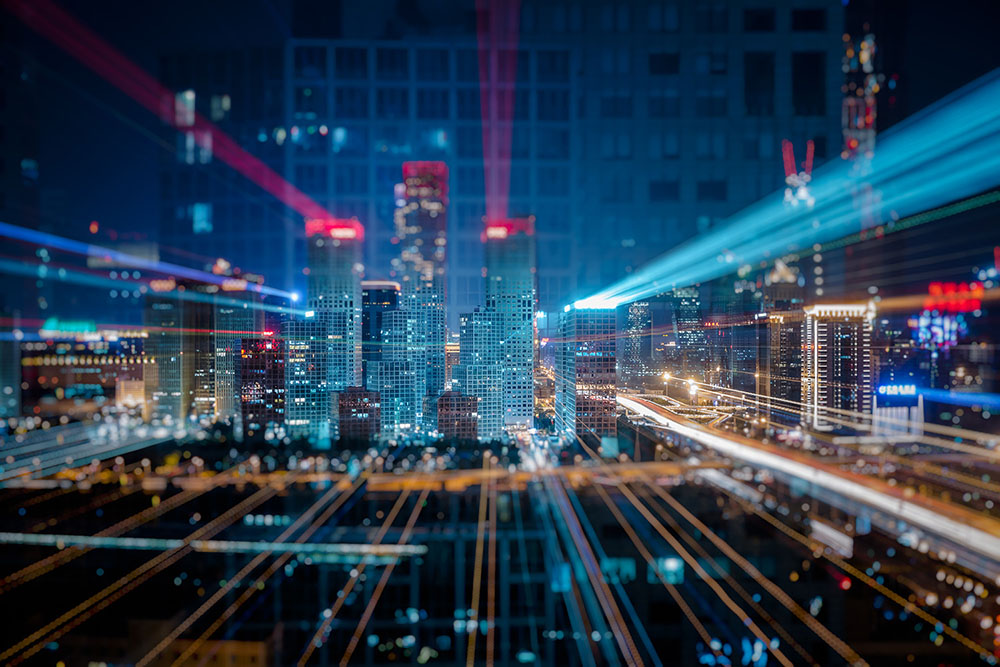 scie di luci che convergono sugli edifici